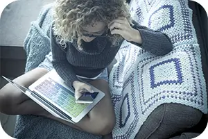 Woman sitting on her couch reviewing plan costs.