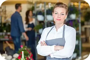 Woman who owns a small business standing in front of her store.